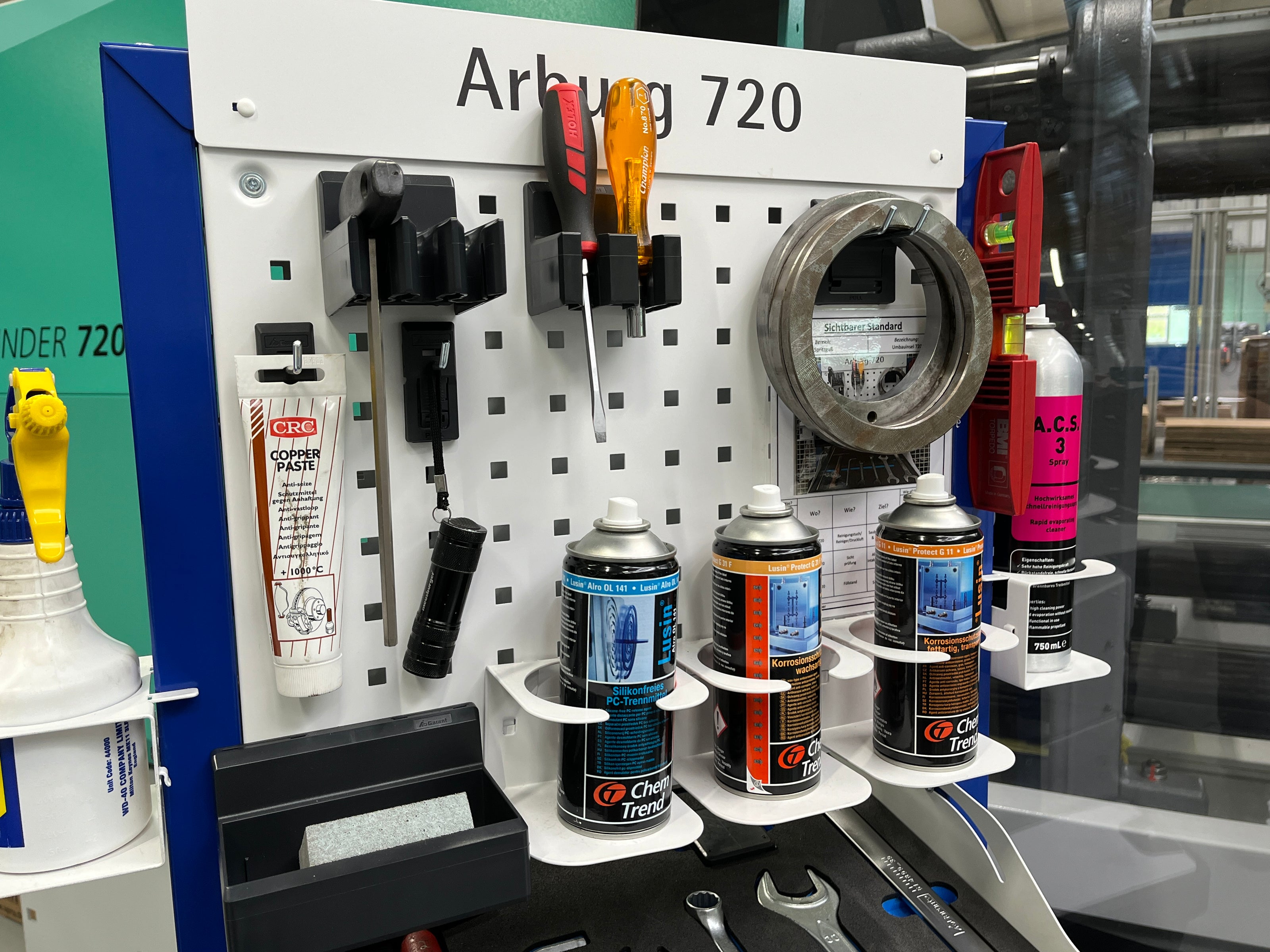 Detailfoto der Rüstinsel für eine Spritzgussmaschine. Mit Werkzeughaken und Dosenhalterungen befestigt an einem Rasterblech, haben Sie alles griffbereit und reduzieren so die Suchzeiten Ihrer Mitarbeiter.